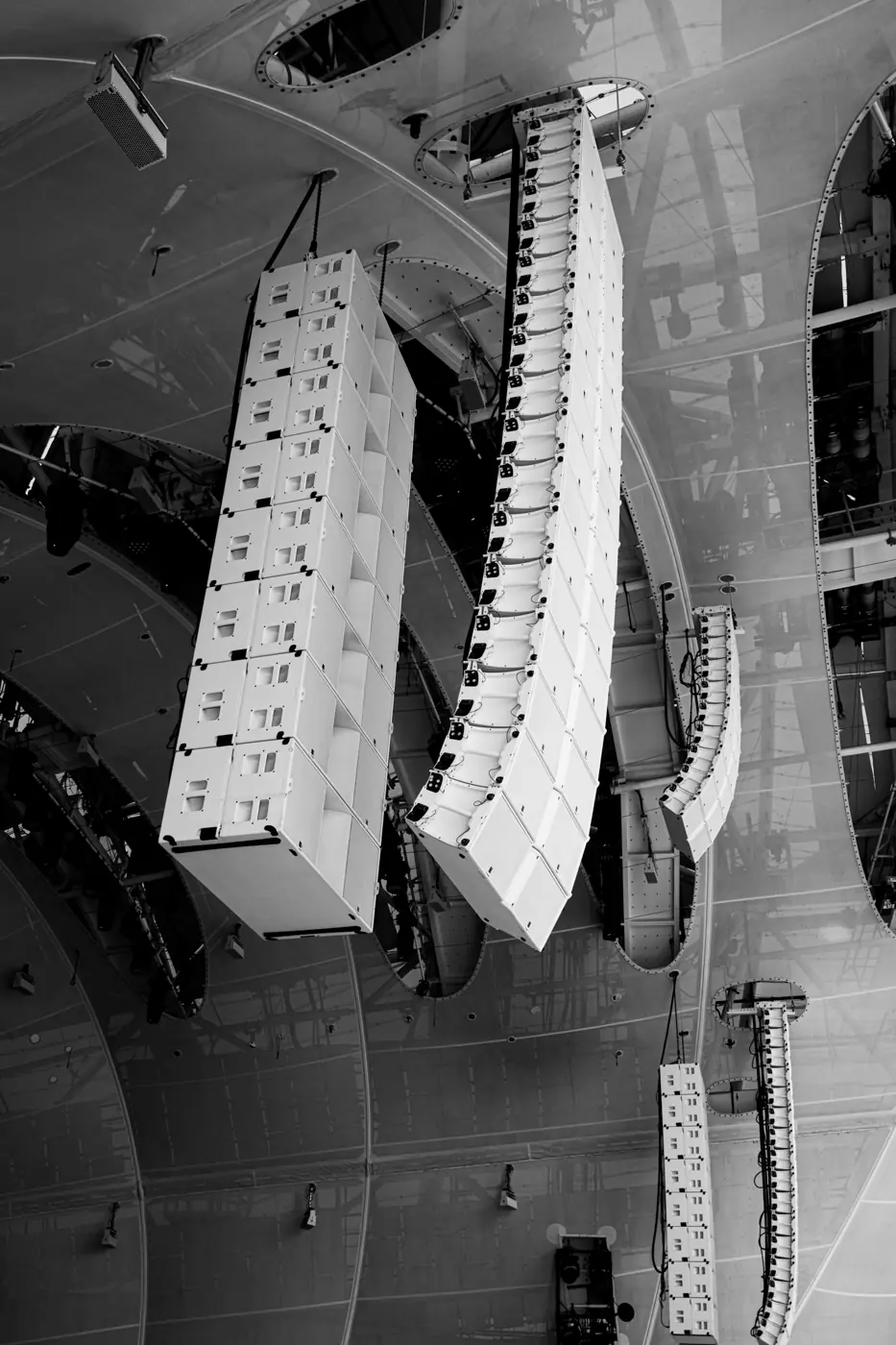Line arrays hung from a hall ceiling